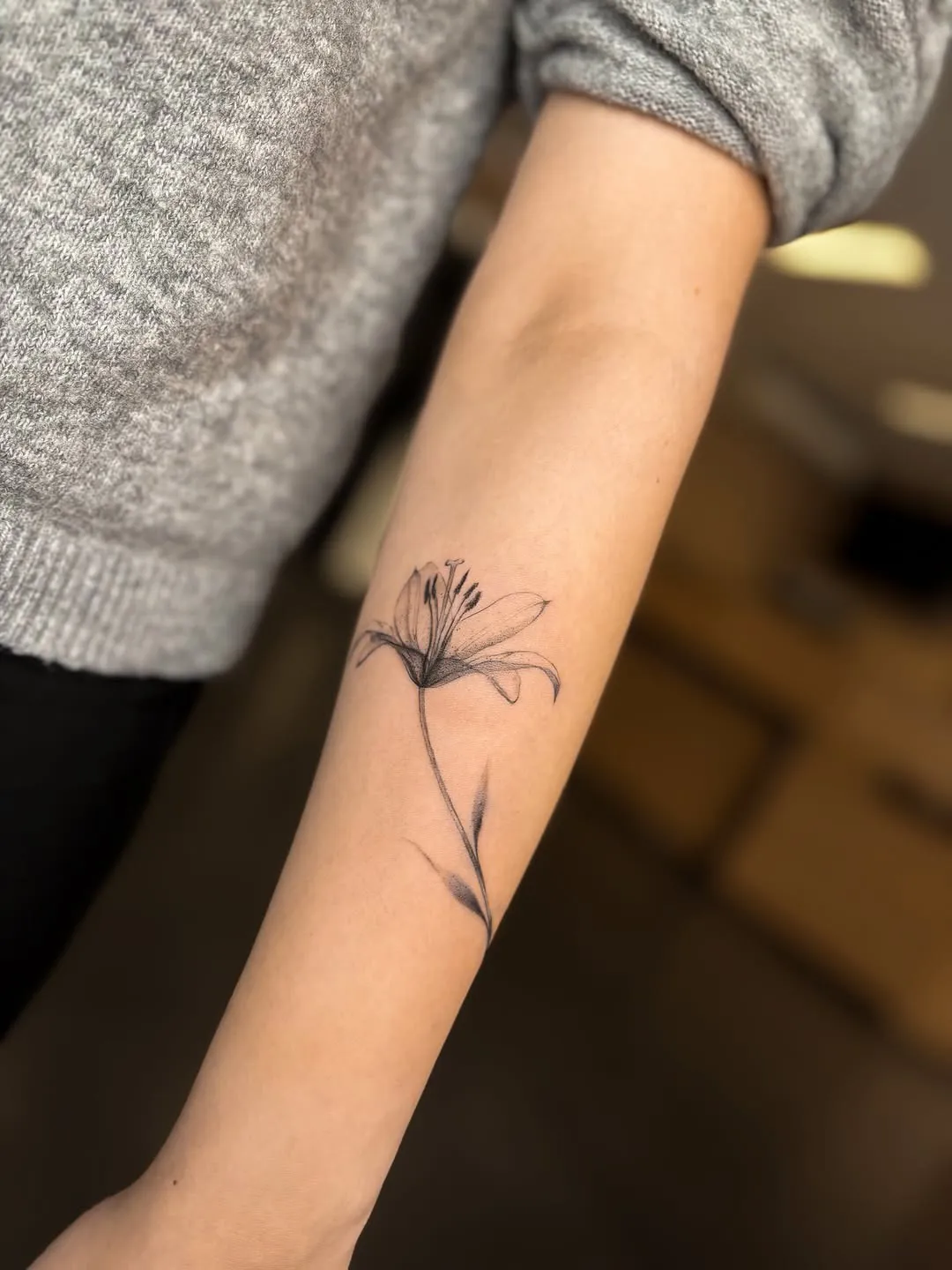 Smalks lilijas tetovējums uz apakšdelma